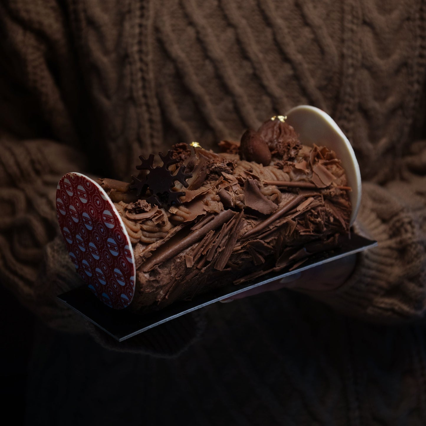 Chocolate cake with a red and white patterned base on a textured brown background